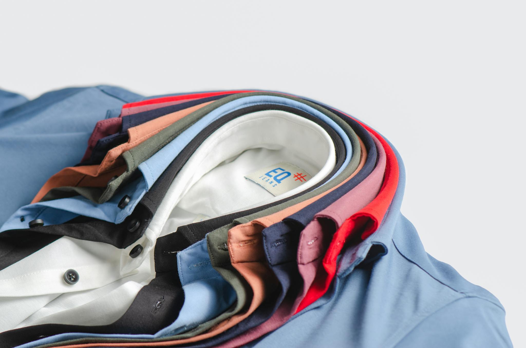 Close-up of neatly stacked colorful men's shirts showcasing vibrant fashion.