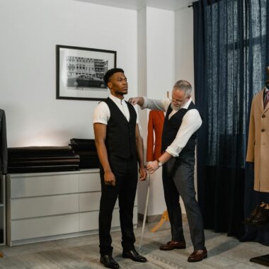 Tailor making precise adjustments to a client's suit in a modern, stylish atelier.